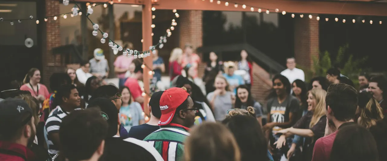 A crowd under string lights in a courtyard